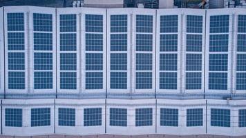 A large solar cell roof on an industrial building Generating electricity for the plant during daytime according to policies and measures to reduce global warming by taking high-angle shots from drones photo