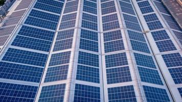 A large solar cell roof on an industrial building Generating electricity for the plant during daytime according to policies and measures to reduce global warming by taking high-angle shots from drones photo