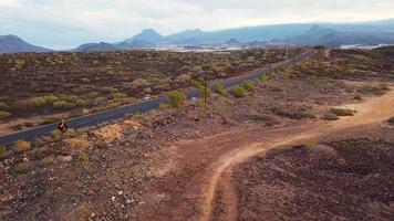 Aerial view of cyclist rider traveling up a desert road video