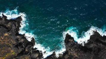 Haut vue de une déserté côte. rocheux rive de le île de tenerife. aérien drone métrage de mer vagues atteindre rive video