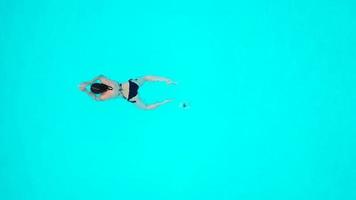 View from the top as a woman jumping and dives into the pool and swims under the water video