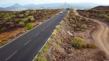 aéreo disparar de un coche paseos a lo largo un Desierto la carretera video