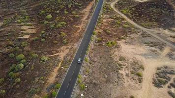 aéreo disparar de un coche paseos a lo largo un Desierto la carretera video