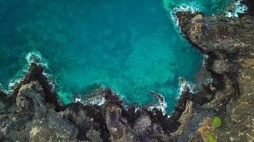 Haut vue de une déserté côte. rocheux rive de le île de tenerife. aérien drone métrage de mer vagues atteindre rive video