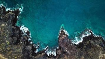 Top view of a deserted coast. Rocky shore of the island of Tenerife. Aerial drone footage of sea waves reaching shore video