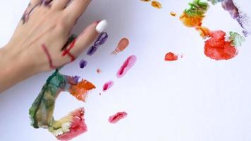 Creative concept - man and woman make prints of their painted hands on a white background video