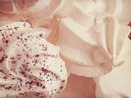 small appetizing white meringues on a plate in close-up photo