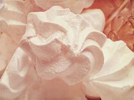 small appetizing white meringues on a plate in close-up photo