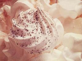 small appetizing white meringues on a plate in close-up photo