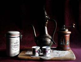Cervia, Ravenna province, Italy February 13, 2023.  Still Life composition of Turkish dallah, coffee pot and manual coffee grinder. photo