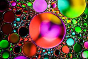 círculos de aceite multicolores en el agua, fondo colorido foto