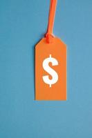 dollar symbol in orange price tag on blue background photo