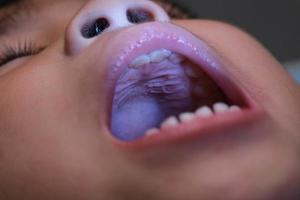 Close-up inside the oral cavity of a healthy child with beautiful rows of baby teeth. Young girl opens mouth revealing upper and lower teeth, hard palate, soft palate, dental and oral health checkup. photo