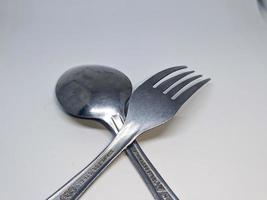 A close up of spoon and fork with white background photo