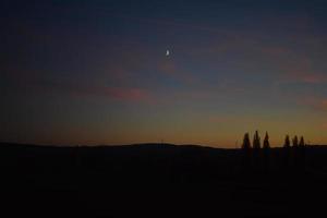 puesta de sol cielo con el Luna encima el vistoso bajo Dom ligero foto