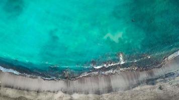 topp se av en folktom svart vulkanisk strand. kust av de ö av teneriffa. antenn Drönare antal fot av hav vågor nå video