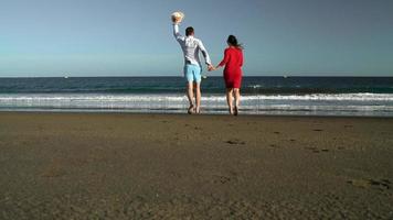 Couple in love carefree walking to the water on the beach. Picturesque ocean coast of Tenerife, Canarian Islands, Spain video