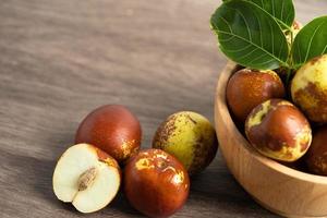 Jujube fruit or Chinese Dates in wooden bowl, healthy food. photo