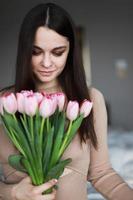 Woman smelling a bouquet of flowers photo