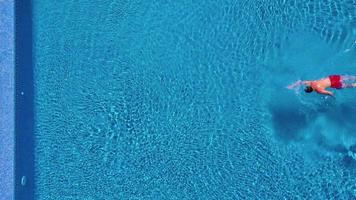 vue de le Haut comme une homme sauter et plongées dans le bassin et nage en dessous de le l'eau video