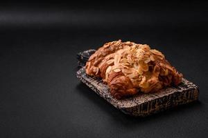 Fresh crispy croissant with almond chips and chocolate filling photo