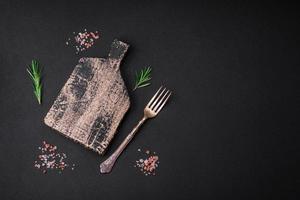 Empty wooden cutting board on dark concrete background photo