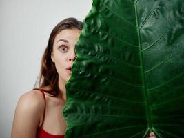Woman behind a big leaf photo
