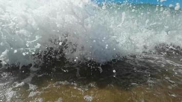 langzaam beweging van groot Golf breken Aan de strand met schuim en surfen video