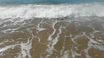 lento movimiento de grande ola rotura en el playa con espuma y navegar video