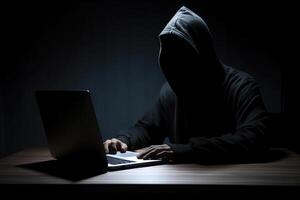 hacker vistiendo negro capucha utilizando ordenador portátil computadora mientras trabajando en oscuro antecedentes. ai generado foto