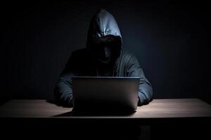 hacker vistiendo negro capucha utilizando ordenador portátil computadora mientras trabajando en oscuro antecedentes. ai generado foto