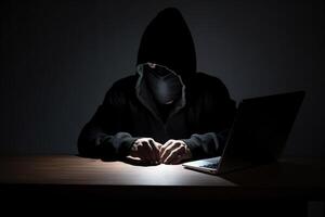 hacker vistiendo negro capucha utilizando ordenador portátil computadora mientras trabajando en oscuro antecedentes. ai generado foto