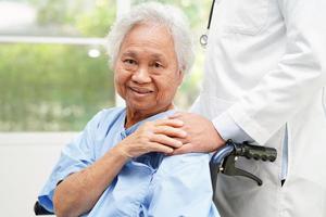 Doctor help Asian elderly woman disability patient sitting on wheelchair in hospital, medical concept. photo