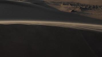 sabbia soffiaggio nel lento movimento al di sopra di deserto sabbia duna picco video