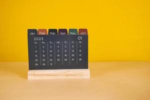 a calendar on table against yellow background photo