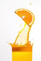 Splash with splashes in a glass with juice from a piece of orange. Vitamins, healthy food. . photo