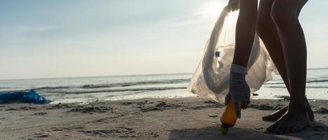 Save water. Volunteer pick up trash garbage at the beach and plastic bottles are difficult decompose prevent harm aquatic life. Earth, Environment, Greening planet, reduce global warming, Save world photo