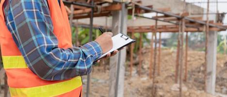 inspector or engineer is inspecting construction and quality assurance new house using a checklist. Engineers or architects or contactor work to build the house before handing it over to the homeowner photo