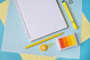 School supplies. Yellow and blue colors. Empty notebook. Flat lay composition. Space for text. photo