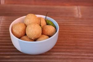 tahu pong is a kind of hollow fried tofu fried tofu which is cut into small rounds. On a white plate. Indonesian street food. photo