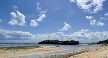 Beautiful beach with a view of the coastline blue sky and white clouds photo