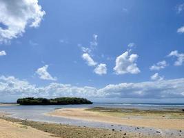 Beautiful beach with a view of the coastline blue sky and white clouds photo