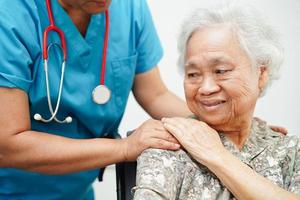 Doctor help Asian elderly woman disability patient sitting on wheelchair in hospital, medical concept. photo