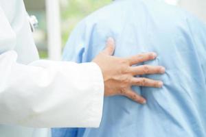 médico tomados de la mano paciente anciana asiática, ayuda y atención en el hospital. foto