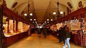 Krakow, Poland, 2023 - tourist buy souvenirs in famous cloth hall market tourist attraction video