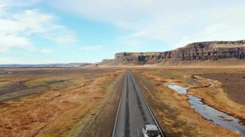 Islande, 2023 - aérien retour vue véhicule conduire sur islandais du sud bague route avec scénique montagnes et sauvage paysage. Islande route voyage concept video