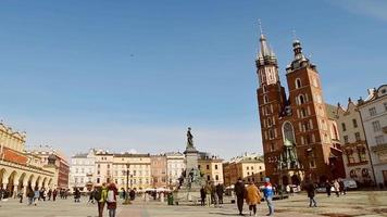 Krakow, Poland, 2023 - tourist sightseeing visit main Krakow square Rynek Glowny in sunny spring day. Famous St. Marry Basilica. Historical WW2 city in Europe video