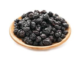 dry blueberry or blackberry in wood plate isolated on white background. pile of dry blueberry or blackberry isolated. dry blueberry or blackberry isolated photo