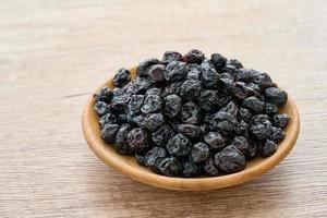 dry blueberry or blackberry in wood plate on wooden table background. pile of dry blueberry or blackberry. dry blueberry or blackberry photo