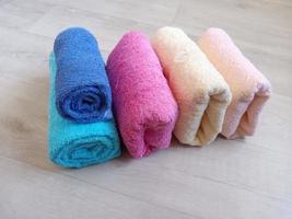 colorful folded towels on wooden background photo